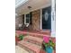 Brick front porch with rocking chairs, front door with glass detail, and potted plants at 103 Beverly Dr, Ladson, SC 29456
