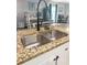 A close-up view of a stainless steel kitchen sink with a modern faucet and granite countertops at 103 Beverly Dr, Ladson, SC 29456