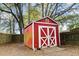 A red shed with white trim in a wooded backyard at 103 Beverly Dr, Ladson, SC 29456