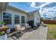 A brick patio with two rocking chairs, grill, chaise lounge, and view of the fenced back yard at 104 Cranston Ln, Summerville, SC 29483
