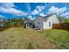 The backyard has a screened in porch and a stone patio with furniture and overlooks a large lawn at 104 Cranston Ln, Summerville, SC 29483
