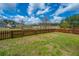 Large, fenced backyard with grass, pond, and gate at 104 Cranston Ln, Summerville, SC 29483