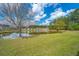 Community pond surrounded by green grass and trees at 104 Cranston Ln, Summerville, SC 29483