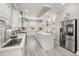 Airy kitchen features recessed lighting, quartz countertops, a stainless steel refrigerator, and sleek white cabinetry at 105 N Gateshead Xing Xing, Goose Creek, SC 29445