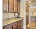 Butler's pantry with dark wood cabinetry and granite countertops, connecting to another room at 113 Blackwater Way, Moncks Corner, SC 29461