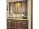 Close up of a butler's pantry with dark wood cabinets, granite countertop, and decor accents at 113 Blackwater Way, Moncks Corner, SC 29461