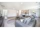 Open-concept living area with hardwood floors, a comfortable sofa, and a modern kitchen in the background at 1132 Mossy Rock Dr, Summerville, SC 29485