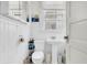 Bathroom featuring a pedestal sink, window, and painted white paneling at 125 Ashley Ave, Charleston, SC 29401