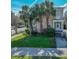 Inviting two-story home with a front porch, complemented by well-kept landscaping and mature palm trees at 125 Ashley Ave, Charleston, SC 29401