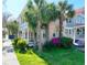Two-story home with a welcoming front porch framed by palm trees and lush green landscaping at 125 Ashley Ave, Charleston, SC 29401