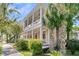 Inviting two-story home with a beautiful balcony, columns, and tropical landscaping at 125 Ashley Ave, Charleston, SC 29401