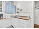 Charming kitchen featuring a stainless steel sink, bright natural light, and open shelving at 125 Ashley Ave, Charleston, SC 29401
