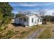 A single story white home with a gray roof and a small porch with driveway at 126 N Hwy 52, Moncks Corner, SC 29461