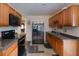 Efficient kitchen layout with stainless steel refrigerator, wood cabinets, and black appliances at 126 N Hwy 52, Moncks Corner, SC 29461