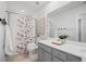 Well-lit bathroom with a floral shower curtain, gray vanity, and ample counter space at 1309 Berry Grove Dr, Summerville, SC 29485