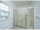 Bright bathroom showcasing a sliding glass door enclosed tub and a nearby window at 1312 Belle Grove Cir, Hanahan, SC 29410