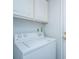 Modern laundry room with white appliances and overhead cabinets for ample storage space at 1312 Belle Grove Cir, Hanahan, SC 29410