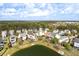 Aerial view of the neighborhood showcasing its houses and lake on a bright sunny day at 138 Sandshell Dr, Charleston, SC 29492