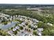 An aerial view of a charming neighborhood surrounding a pond with mature trees and marshes at 138 Sandshell Dr, Charleston, SC 29492