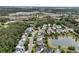 An aerial view of a charming neighborhood surrounding a pond with mature trees at 138 Sandshell Dr, Charleston, SC 29492