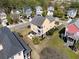 Aerial view of a yellow, two-story home with double balconies, set amongst neighborhood homes and lush landscaping at 138 Sandshell Dr, Charleston, SC 29492