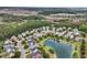An aerial view of a charming neighborhood surrounding a pond with mature trees and marshes at 138 Sandshell Dr, Charleston, SC 29492