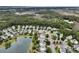 An aerial view of a charming neighborhood surrounding a pond with mature trees at 138 Sandshell Dr, Charleston, SC 29492