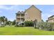 Lovely backyard view of the home featuring a manicured lawn and tiered deck with white railings at 138 Sandshell Dr, Charleston, SC 29492