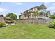 Fenced backyard featuring a patio, wooden gazebo, palm tree, and lush green lawn at 138 Sandshell Dr, Charleston, SC 29492