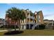 Charming yellow home featuring double porches, well-maintained landscaping, and a neatly manicured lawn at 138 Sandshell Dr, Charleston, SC 29492