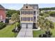 Home exterior featuring a two-car garage, palm trees, and a well-manicured lawn at 138 Sandshell Dr, Charleston, SC 29492