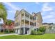 Charming yellow home with a double-decker porch, garage, and well-maintained lawn at 138 Sandshell Dr, Charleston, SC 29492