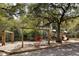 Community playground featuring mature trees, swings, slide, and playset at 138 Sandshell Dr, Charleston, SC 29492