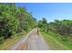 Natural walking path with trees, green grass, and bollards lining the trail under a clear blue sky at 138 Sandshell Dr, Charleston, SC 29492