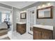 Dual vanities with dark wood cabinets, white countertops and flooring create a spacious ensuite at 1406 Iroquois St, North Charleston, SC 29405
