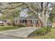 Inviting brick home with mature landscaping, classic black shutters, and a spacious driveway at 1406 Iroquois St, North Charleston, SC 29405