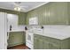 The kitchen features olive green cabinets, white countertops, and modern appliances at 1406 Iroquois St, North Charleston, SC 29405