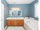 Bathroom with double sinks, a jacuzzi bathtub, and oak cabinets at 1433 Oakhurst Dr, Mount Pleasant, SC 29466