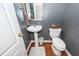 A compact powder room featuring a pedestal sink, toilet, and gray walls at 1433 Oakhurst Dr, Mount Pleasant, SC 29466