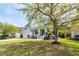 Charming home with a welcoming front porch, a well-manicured lawn and a mature tree providing shade at 1433 Oakhurst Dr, Mount Pleasant, SC 29466