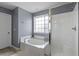 Modern bathroom with a soaking tub and a shower with white tile and glass doors at 1586 Innkeeper Ln, Johns Island, SC 29455