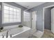 Modern bathroom with a large window over a soaking tub and glass-enclosed shower at 1586 Innkeeper Ln, Johns Island, SC 29455