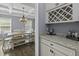 Elegant dining area displays a coffered ceiling, modern chandelier, and seamlessly connects to a dining table at 1586 Innkeeper Ln, Johns Island, SC 29455