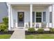 Inviting front porch with seating, lovely landscaping, and a welcoming yellow wreath at 1586 Innkeeper Ln, Johns Island, SC 29455