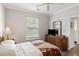 This is a bright bedroom featuring a ceiling fan, window with blinds, dresser, and access to another room at 1600 Long Grove Dr # 1226, Mount Pleasant, SC 29464