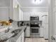 Bright kitchen with white cabinets, granite countertops, and stainless steel appliances at 1600 Long Grove Dr # 1226, Mount Pleasant, SC 29464