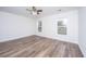 Bright bedroom with wood-look flooring, two windows, a ceiling fan, and fresh paint at 1725 W Avalon Cir, Charleston, SC 29407
