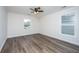 A bright bedroom featuring wood-look flooring, a ceiling fan, and natural light from windows at 1725 W Avalon Cir, Charleston, SC 29407