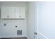 A white laundry room with white cabinets, utility connections, and a door to the hall at 1725 W Avalon Cir, Charleston, SC 29407