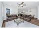 Bright living room with a ceiling fan, leather sofas, and seamless flow into the adjacent kitchen at 1725 W Avalon Cir, Charleston, SC 29407